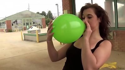 Fifi Foxx Blows and pops Balloons Outdoors